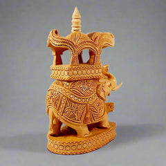 A 23cm wooden elephant statue with beautifully decorated tusks and ornate headgear.