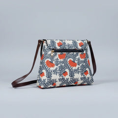 The back side of a floral print sling bag highlighting the functional exterior zipper pocket and smooth vegan leather finish.