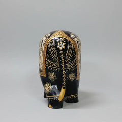 Back view of black wooden elephant figurine with golden and white miniature detailing