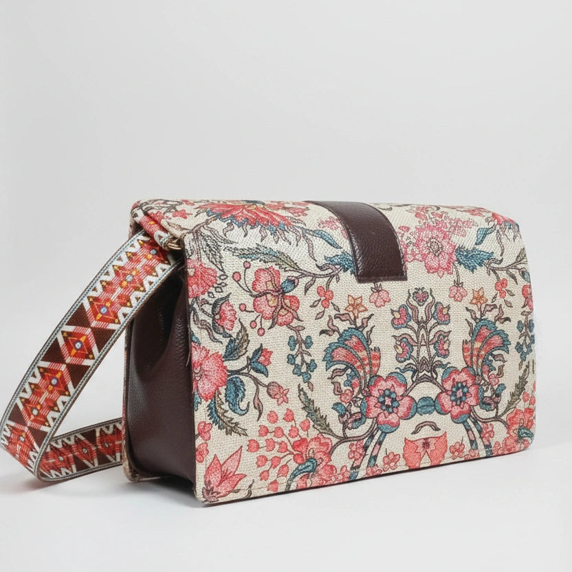 The side profile of the woven handbag highlighting the adjustable sling made from matching floral fabric.