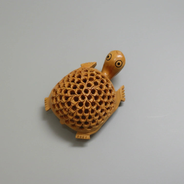 Close up of the delicate lattice and undercut carving work on the wooden tortoise statue.