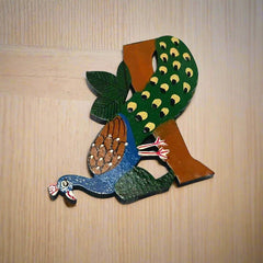 Decorative wooden fridge magnet featuring a colorful peacock design