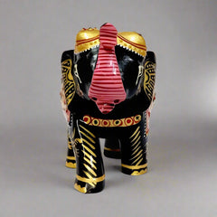 Decorative wooden elephant statue with golden embossed artwork on back and stomach.