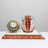 Decorative marble Ganesh clock placed on an office desk as a spiritual decor item.