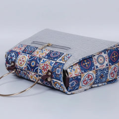 Rear view of floral embellished bag showing side sling and back zip pocket