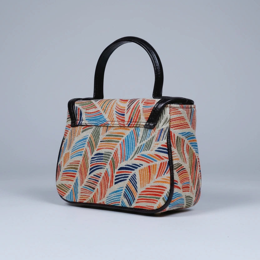 Close-up of the PU leather top handle and floral fabric texture.