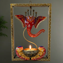 Hand-painted metal wall frame featuring Lord Ganesha with a built-in tealight candle stand.