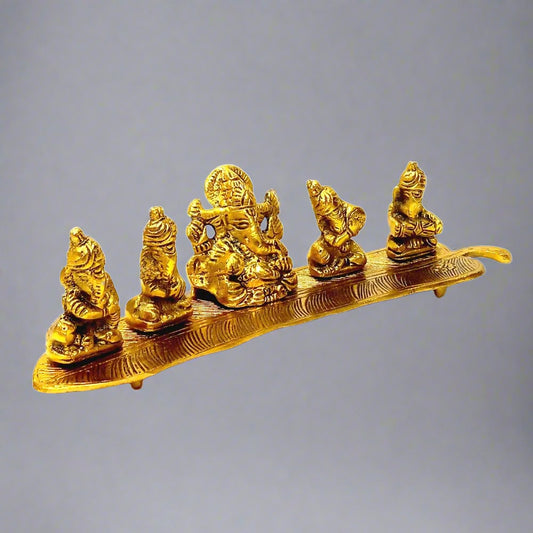 A golden metal Ganesh idol sitting on a leaf and playing music, a unique showpiece.