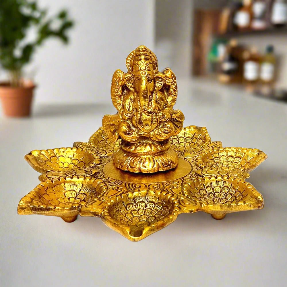 A golden metal Ganesha statue with seven diyas, perfect for puja or home decor.