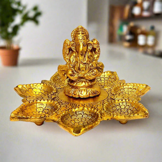 A golden metal Ganesha statue with seven diyas, perfect for puja or home decor.