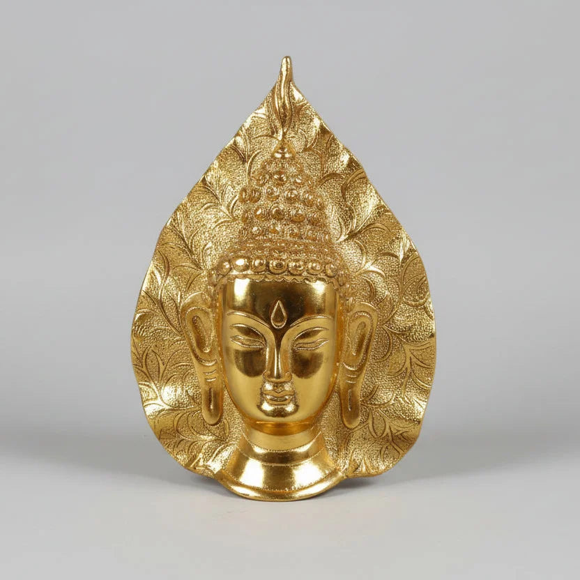 Closeup of serene hand-painted Buddha face on golden oxidized metal wall art piece.