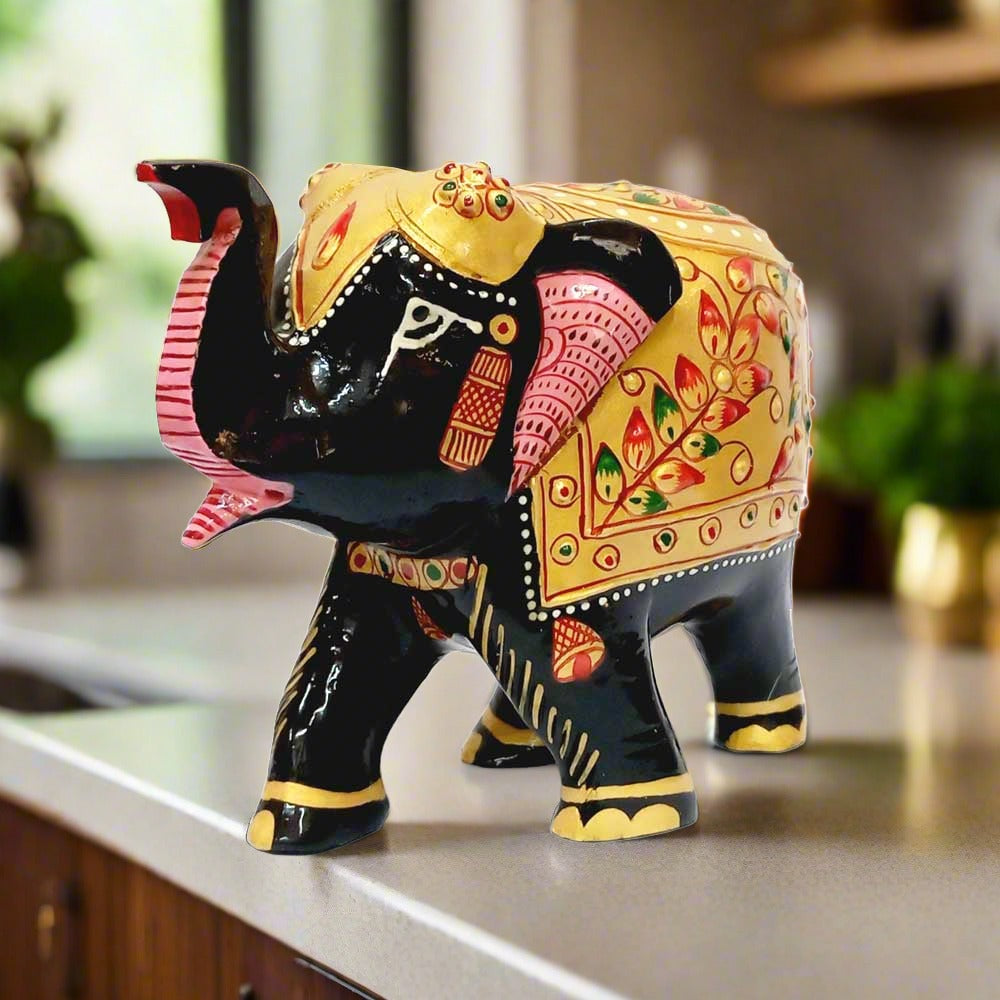 Golden painted wooden elephant showpiece with black base design.