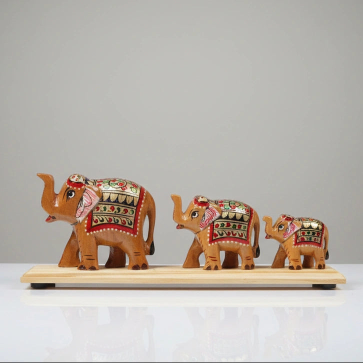 Front view of a 9-inch hand-painted elephant bridge statue made from Kadamb wood, featuring three elephants in a small-to-big sequence with a polished finish.