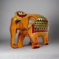 Hand-painted wooden elephant featuring red and green floral artwork on gold background, perfect decorative gift item