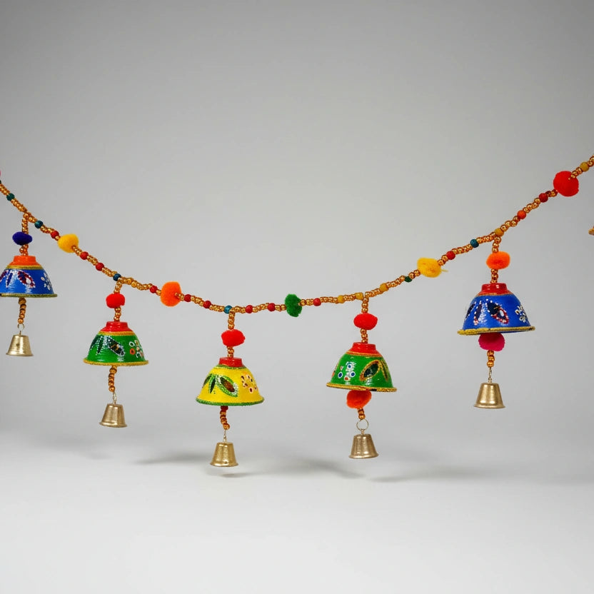 Handmade Bandarwal toran made of papermache featuring colorful hand paintings, bells, and pom-poms.