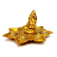 An intricately crafted Ganapati statue with seven diyas, a visual delight and spiritual focal point.