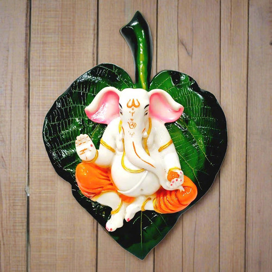 A marble dust Ganesha wall hanging, featuring Lord Ganesha on a green peepal leaf.