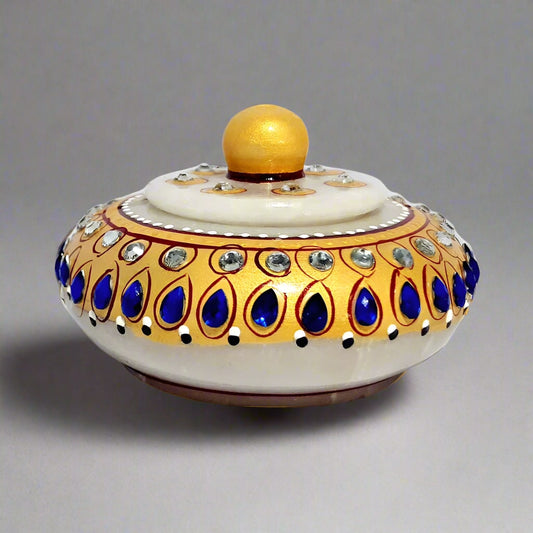 Marble kumkum dibbi with lid featuring intricate hand painting and blue-white kundan studs, ideal for pooja.