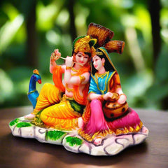 A multi-color Radha Krishna showpiece sitting in front of a tree, a perfect statue for home and office.