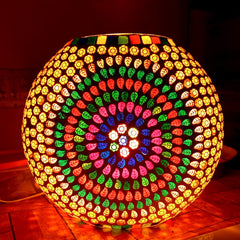 An amazing oval mosaic glass lamp that gives off a beautiful and colorful light.