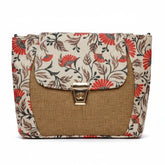 Front view of a pastel floral jacquard sling bag with golden button and dark brown trim