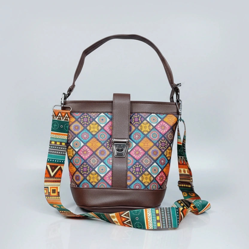 Blossom Oval Sling featuring an intricate Patola floral print fabric with premium PU leather trim and a top handle.