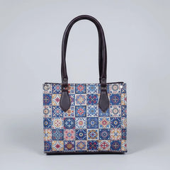 Front view of a Patola handbag featuring vibrant traditional patterns and brown synthetic PU leather handles.