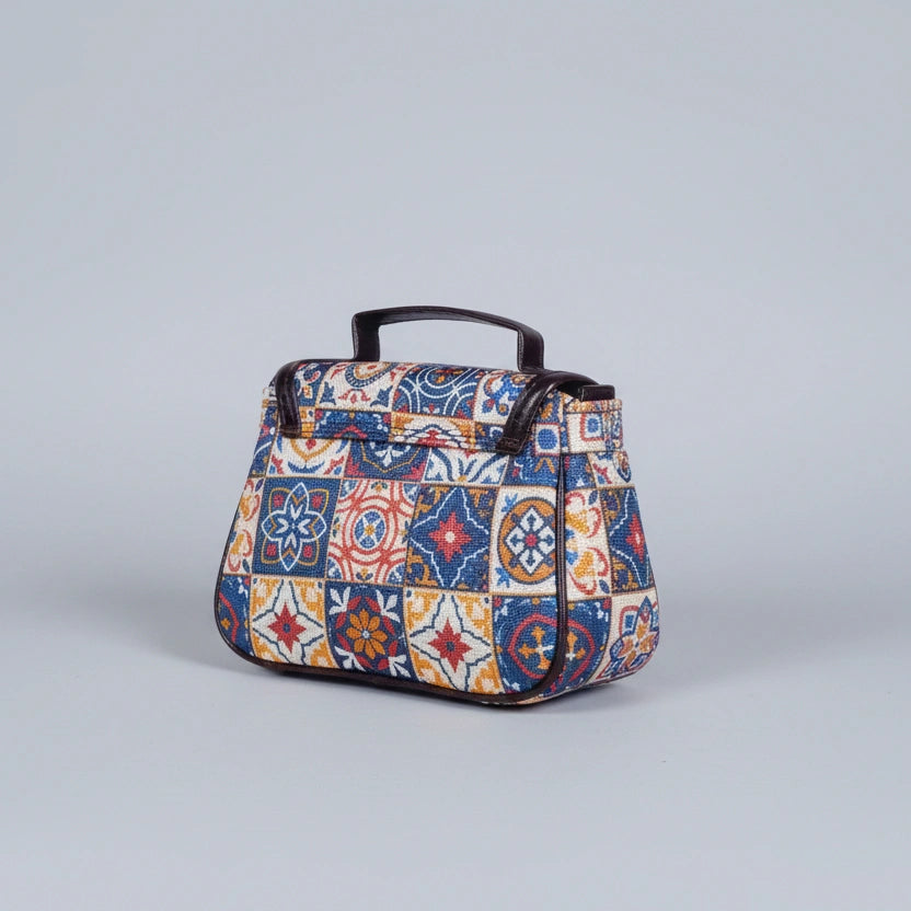 Close-up of the reinforced PU leather top handle and floral fabric texture