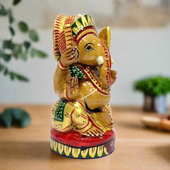 A round wooden Ganesha showpiece, decorated with beautiful multi-color hand painting.