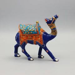 A high-necked metal camel idol with intricate blue enamel and hand-painted Meenakari saddle, displayed as a sophisticated office desk centerpiece.