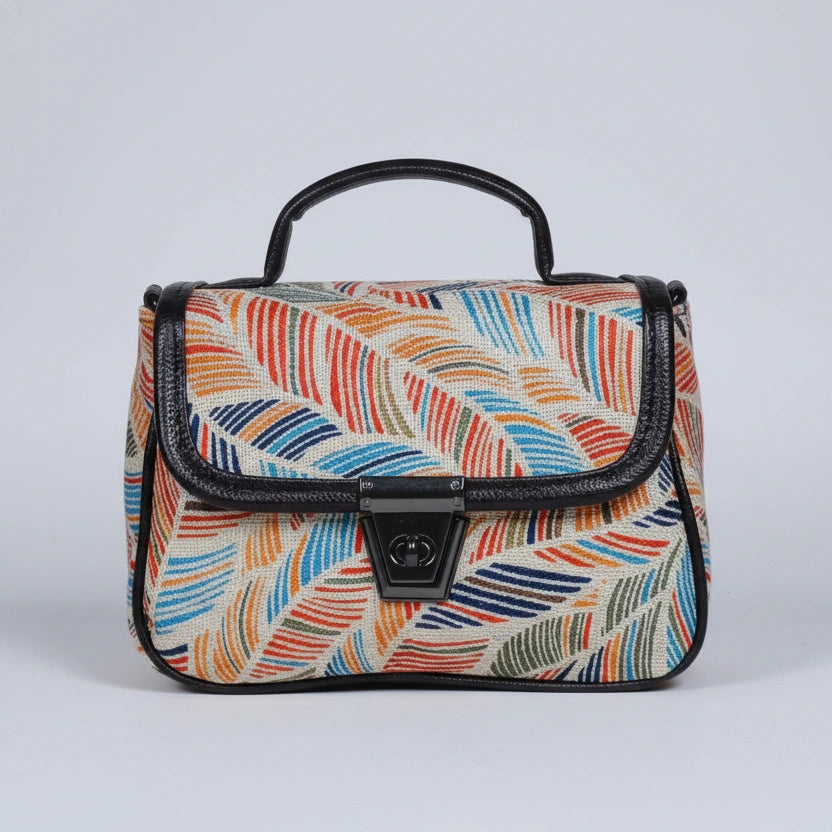 Front view of a small floral print ethnic crossbody bag with button closure.