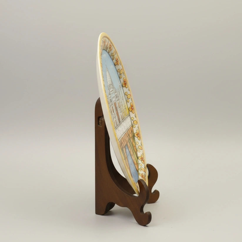 Artisanal marble plate with Taj Mahal painting displayed on an elegant dark wood stand, perfect for luxury home or office decor.