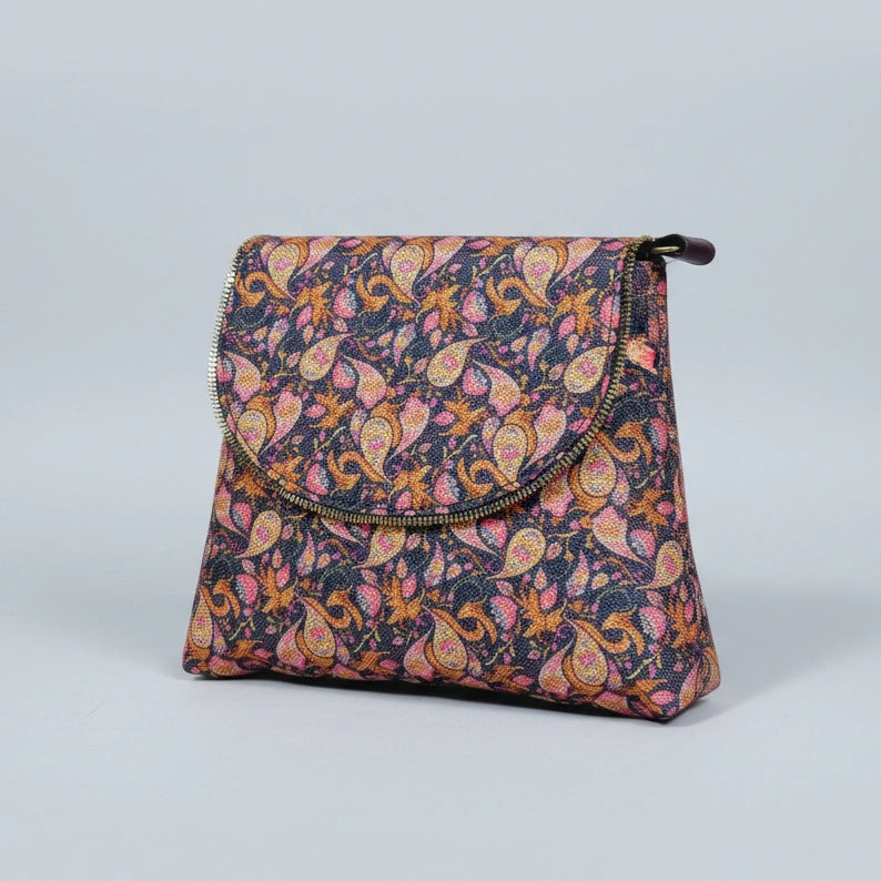 Women’s botanical messenger bag featuring a colorful woven floral print and elegant brown PU leather trim.