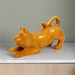 A hand-carved wooden cat statue with a detailed design.