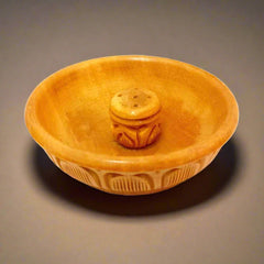 A hand-carved wooden incense holder for sticks and cones.