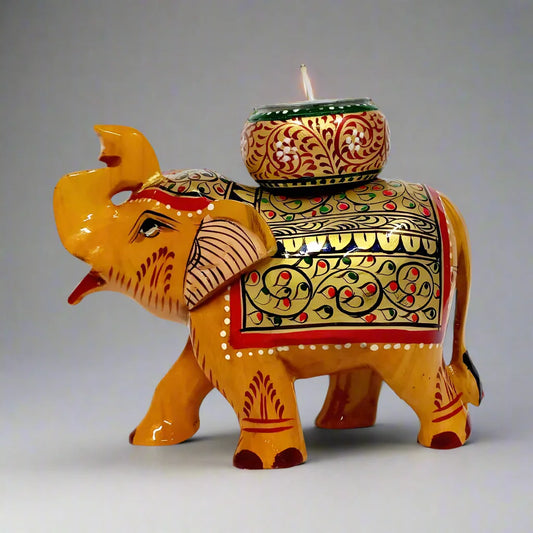 Handmade wooden elephant candle holder with a round candle stand on top of the long trunk, decorated with gold, red, blue, and black hand painting.