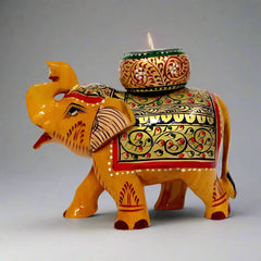 Handmade wooden elephant candle holder with a round candle stand on top of the long trunk, decorated with gold, red, blue, and black hand painting.