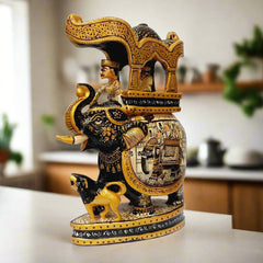 A wooden elephant figurine depicting a king riding and a lion at its feet, a true showpiece.