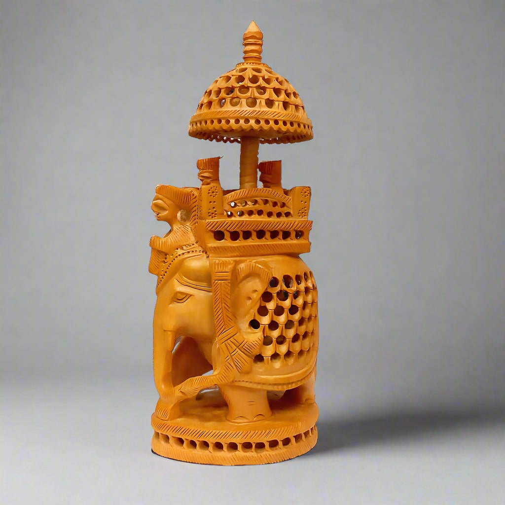 A wooden elephant statue with king and queen figurines, featuring an intricate latticework design.