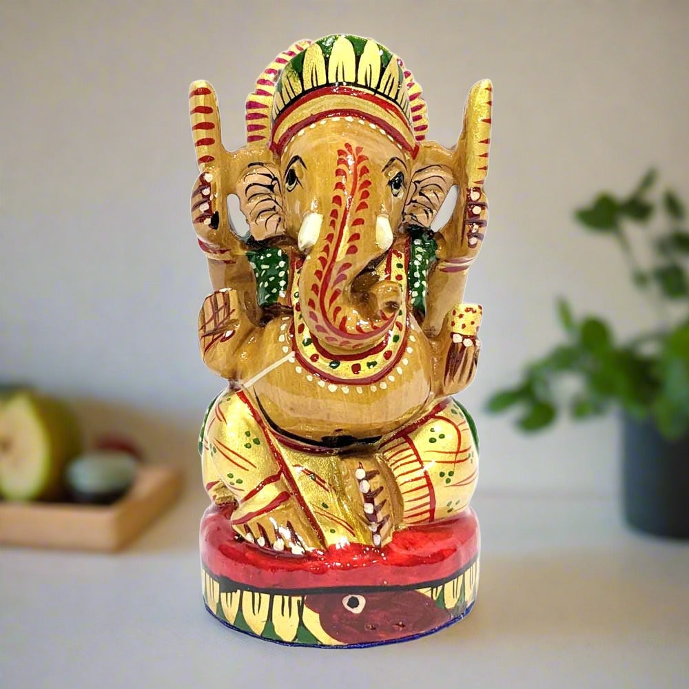 A wooden Ganesh murti with laddoos in one hand, considered best for worship in a home temple.