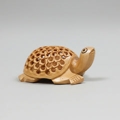 Wooden tortoise statue showing the intricate lattice undercut carving design on its back.