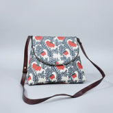 Front view of an 8x9 inch woven floral sling bag featuring a textured fabric body and tan PU leather accents.