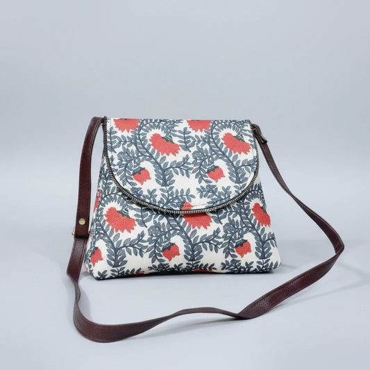 Front view of an 8x9 inch woven floral sling bag featuring a textured fabric body and tan PU leather accents.