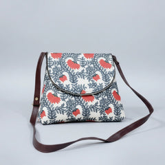 Front view of an 8x9 inch woven floral sling bag featuring a textured fabric body and tan PU leather accents.