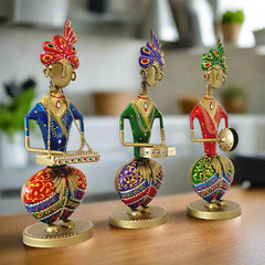 A 3-piece set of seated Rajasthani baja players, reminiscent of shehnai players in a wedding.