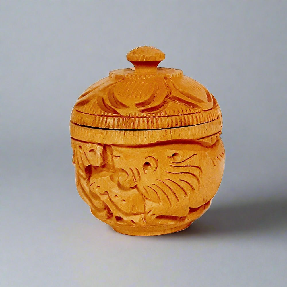 Artisan-crafted round wooden kumkum box featuring bangle style threading and detailed handiwork.