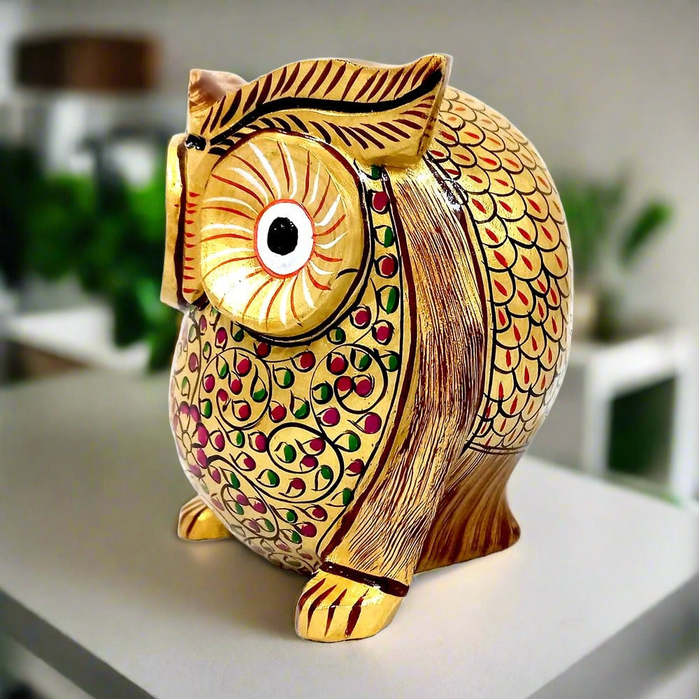 A beautiful golden owl statue with a thick, round shape and big eyes, decorated with hand painting.