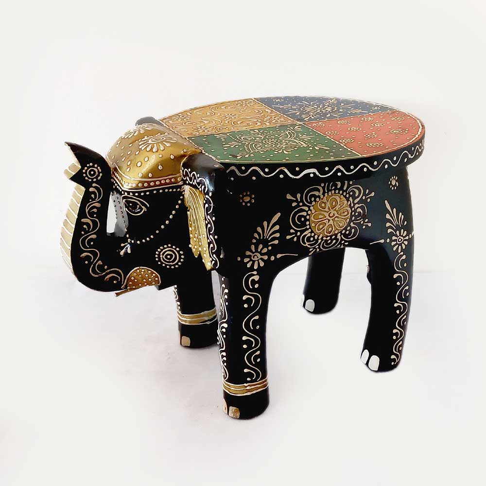A beautiful wooden elephant stool with four legs and a tail, a decorative piece for any room.