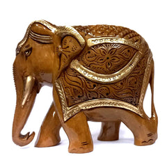 A brown carved elephant with intricate carvings on its back and belly.