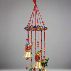 A colorful papermache toran with elephant, golden bell, beads, and thread work.